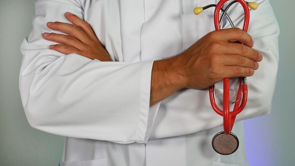 doctor in a coat crossing his arms with stethoscope